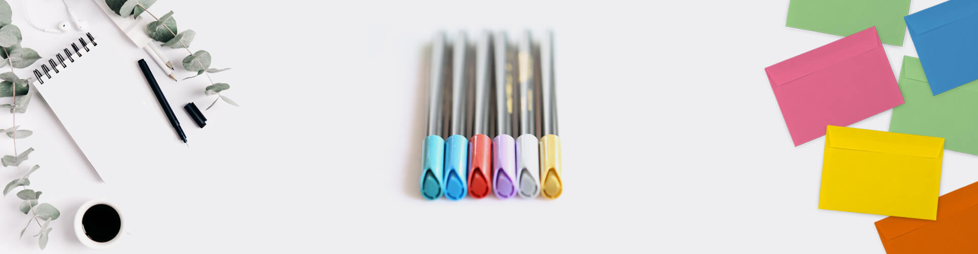 Bild mit verschieden farbigen Briefumschlägen Edding-Metallic-Stiften auf enem Schreibtisch
